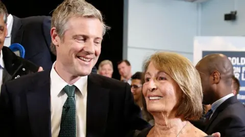 Getty Images Zac stands at a campaign event with his arm round his mother Lady Annabel. They are both smiling.