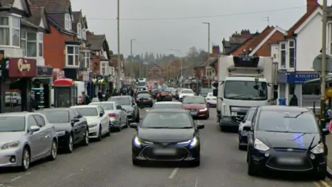 Google Street view of Evington Road with cars parked on either side of the road