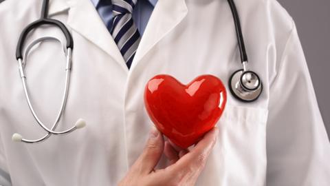 A doctor holding a love heart
