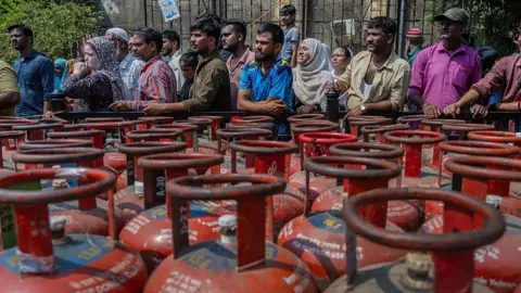 Getty Images Residents queue up with empty cylinders for LPG cooking gas refills in India's Mumbai on 26 March, amid supply concerns triggered by the Middle East conflict.