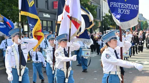 Pacemaker Girls holding banners and marching in the parade in Holywood