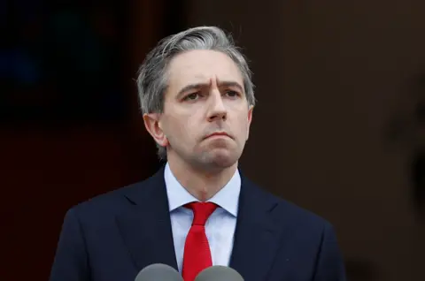 PA Simon Harris in a blyue suit and red tie