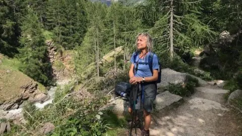 SUPPLIED A LADY WALKING ON A HILLSIDE IN A BLUE TOP