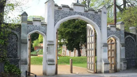 A stone gate including the wooden gates on the outskirts of the gardens.