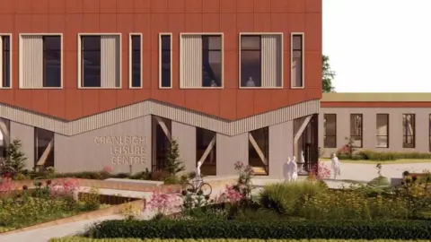 A computer generated image of the outside of a two-storey building with a dark brown first floor on top of a paler ground floor with Cranleigh Leisure Centre engraved on the wall