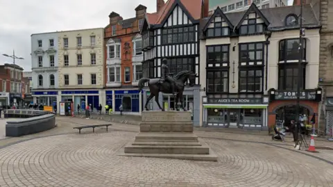 General view of a statue of Prince Albert o a horse in Wolverhampton's Queen Square, There are a range of buildings including a historic one with a black and white facade