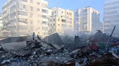 EPA A man looks at the remains of buildings destroyed in the Israeli strike that killed Hezbollah leader Hassan Nasrallah, in Beirut's southern suburbs, Lebanon (29 September 2024)