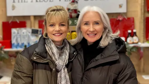 Louise Reilly and Lisa Walsh in front of market stall