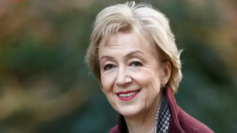 Reuters Andrea Leadsom with blonde hair wearing burgundy jacket