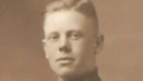 Lynne Strickland A sepia photo shows David Hartley Kind looking at the camera. The collar of his Royal Marines uniform can be seen.
