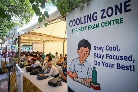 Hindustan Times via Getty Images Parents of NEET candidates wait at a cooling station outside an examination centre in Delhi 