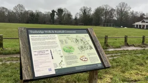 Sign board with map of Tunbridge Wells and Rusthall Commons overlooking Linden Park Cricket Club pitch