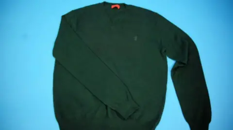 North Wales Police A green jumper laying flat on a surface