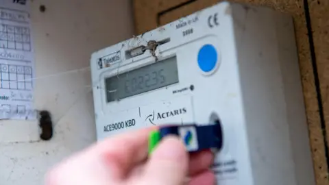 A customer checks the credit on a prepayment electricity meter. 