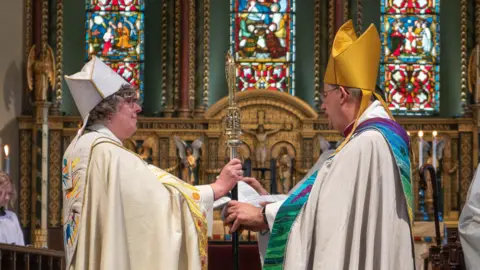 Emma Thompson Bishop Gregory in cream and gold robes at her consecration with the Archbishop of York.