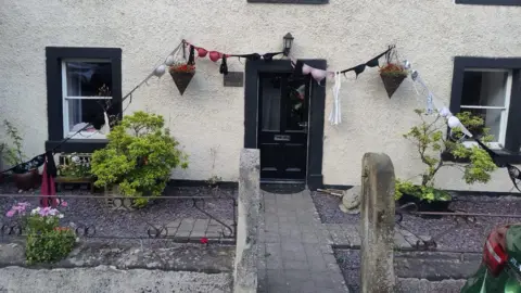 Louise Stevenson A number of bras across a doorway.