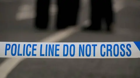 A generic stock photo of police tape at a crime scene, with the words: police line do not cross.