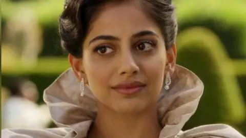 Banita Sandhu as Miss Malhotra