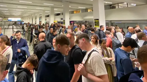 Passengers queue up amid chaos at Manchester airport