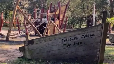 A wooden boat feature with a play area inside it.