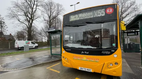 A Sanders Coaches bus outside a bus stop