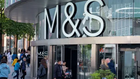 People walking outside a Marks & Spencer store