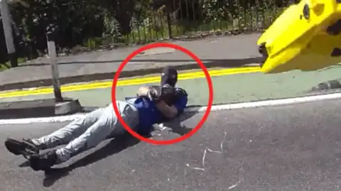 Man in balaclava points weapon at camera