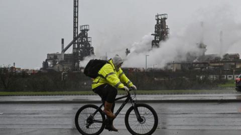 A man cycles past the Port Talbot steelworks