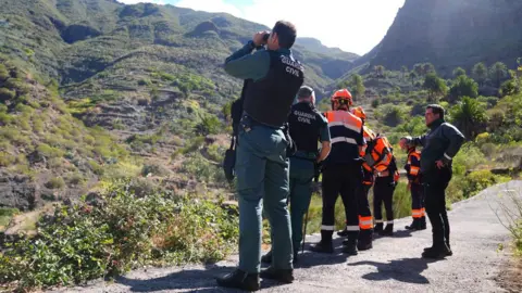 PA Media A Guardia Civil officer peering into the abyss with binoculars