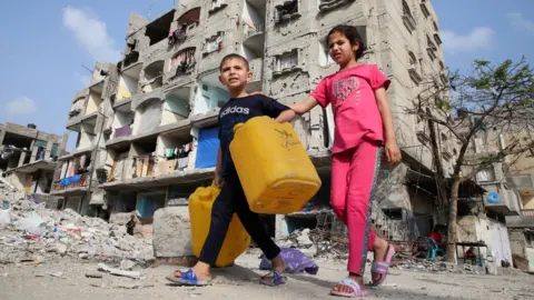 Reuters Palestinian children walk past a house damaged in an Israeli strike, amid the ongoing conflict between Israel and the Palestinian Islamist group Hamas, in Rafah, in the southern Gaza Strip, May 1, 2024.
