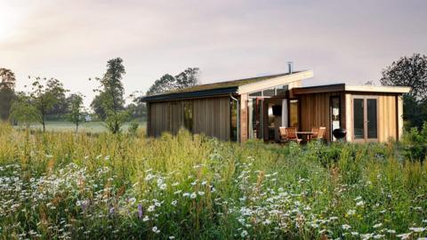 An artist's impression of a proposed wooden-style lodge surrounded by wildflowers 
