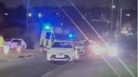 Gary Hurst The police scene, with flashing lights and patrol cars