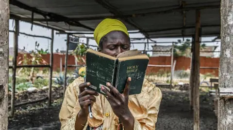 Gerald Anderson/Anadolu/Getty Images A man is reading a black bible under a roof in Nairobi, Kenya - Sunday 24 August 2025.