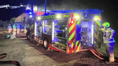 Suffolk Fire and Rescue Service Firefighers at the scene of a farmhouse fire in Saxmundham, Suffolk