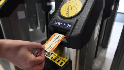 Getty Images Card train ticket being entered into a ticket barrier machine