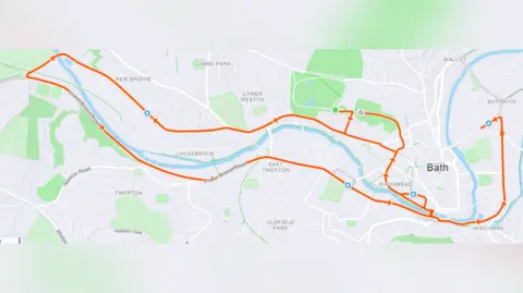 London Marathon Events A map of Bath with the route of the Bath Half Marathon marked out in orange arrows. The route runs through the centre of the city and largely tracks the course of the River Avon. 