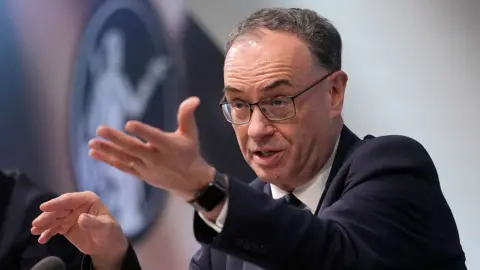 A head and shoulders shot of Bank of England governer Andrew Bailey gesturing and looking away from camera as he speaks at a press conference in London on 6 February