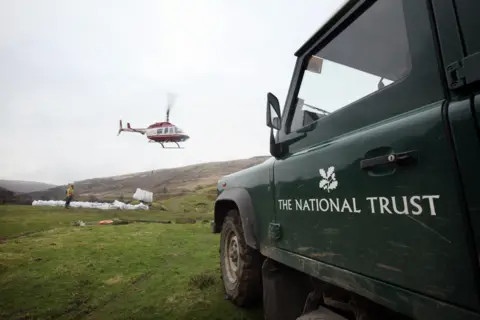 Getty Images A helicopter being used to airlift materials to the remote moors and the plateau of Kinder Scout in 2011