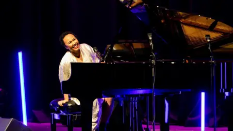 Victoria Wai Adele Sandé on stage, performing at the piano.