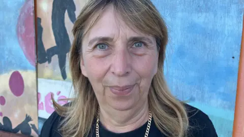 Julie Nerton looking at the camera in front of a graffitied wall at the Rollercoaster Youth Centre in Bridgwater.