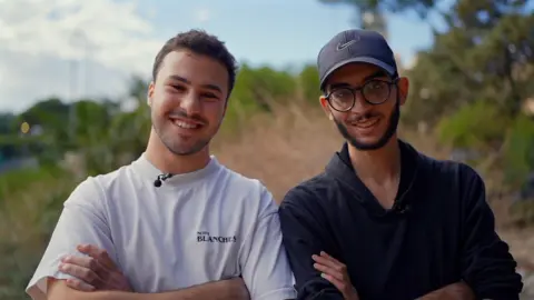 Adam Kassak (on the left) and Ali Baydoun smile at the camera with their arms crossed in front of their chests