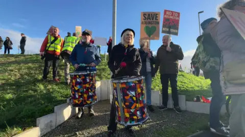 Protestors holding signs and drums