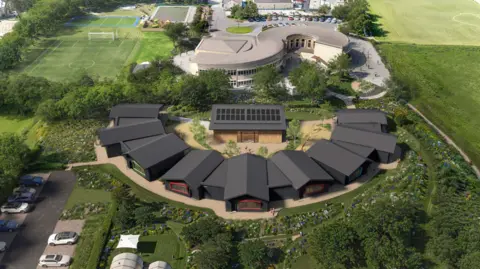 Dyson A computer generated aerial view of the plans. The school building looks like a grey S shape. Next to it are the proposed 9 new classrooms which are black shed style buildings in a curved C shape with brightly coloured window frames. Both buildings are surrounded by playing fields. To the left is a car park.