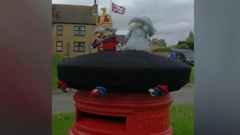 Ashley Briggs Coronation-themed knitted topper 