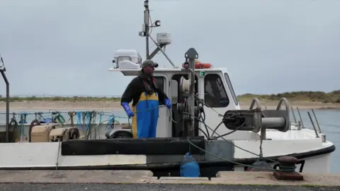 Peter on his boat as it departs from the dock.
