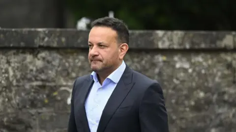 PA Media Leo Varadkar, with dark hair, wearing dark suit and blue shirt, at funeral of Lord Mount Charles in Slane.