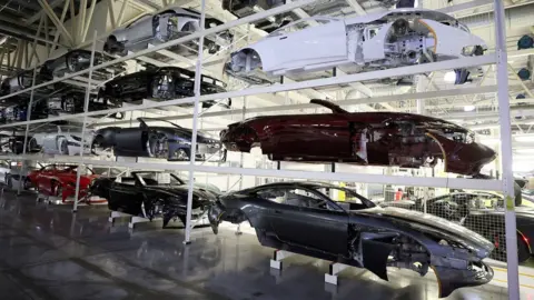 Car bodies are stored on shelves at the Aston Martin factory in Gaydon, Britain