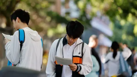 Getty Images Students make last-minute reviews before entering the examination venue for the 2026 China's National College Entrance Exam on June 7, 2026 in Beijing, China. 