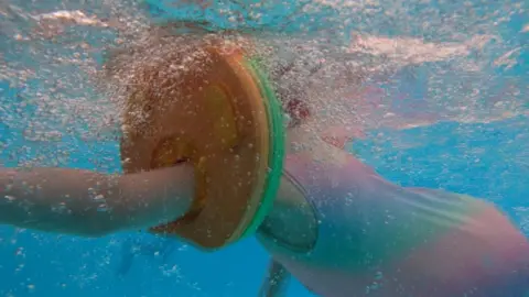a child swimmign with arm bands