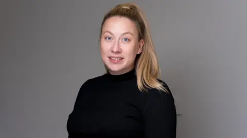 A picture of a woman wearing a black top
